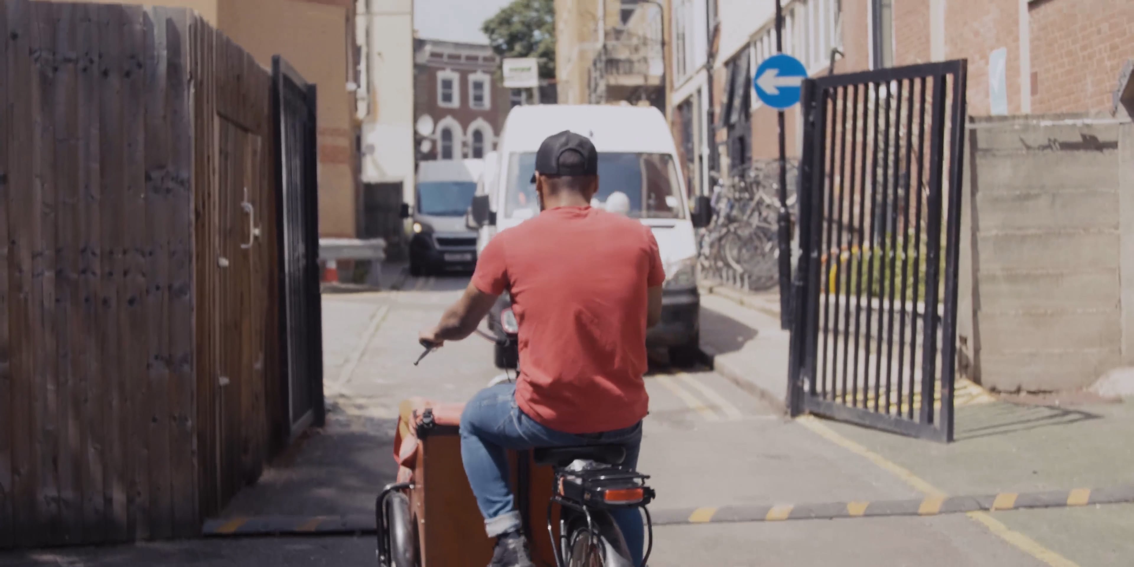 A man riding his bicycle along a busy street