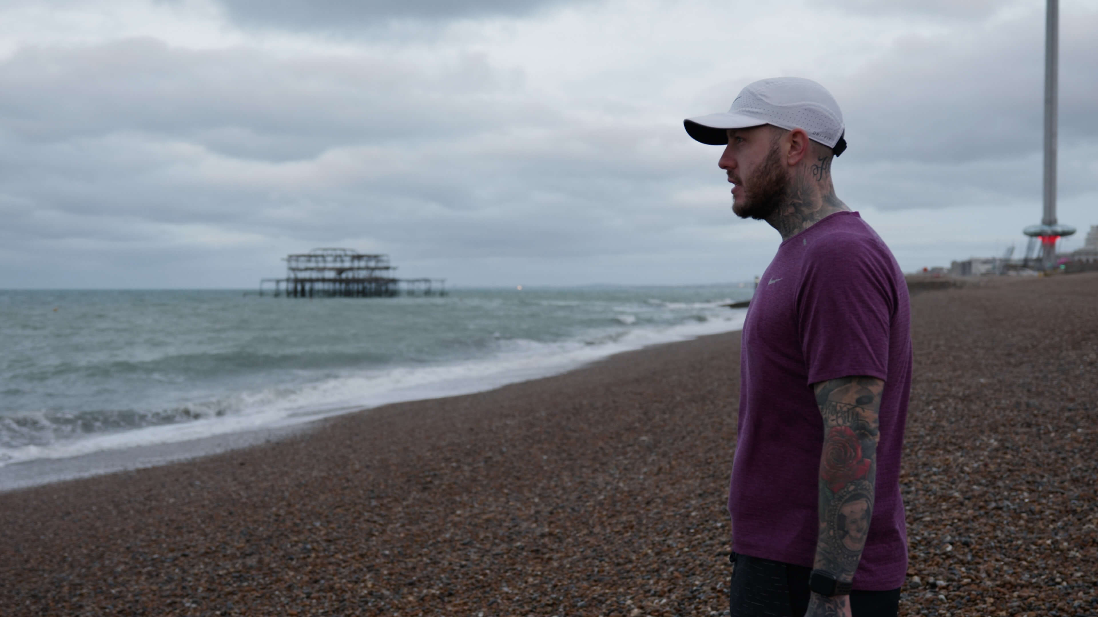 Man standing on the beach looking out to sea