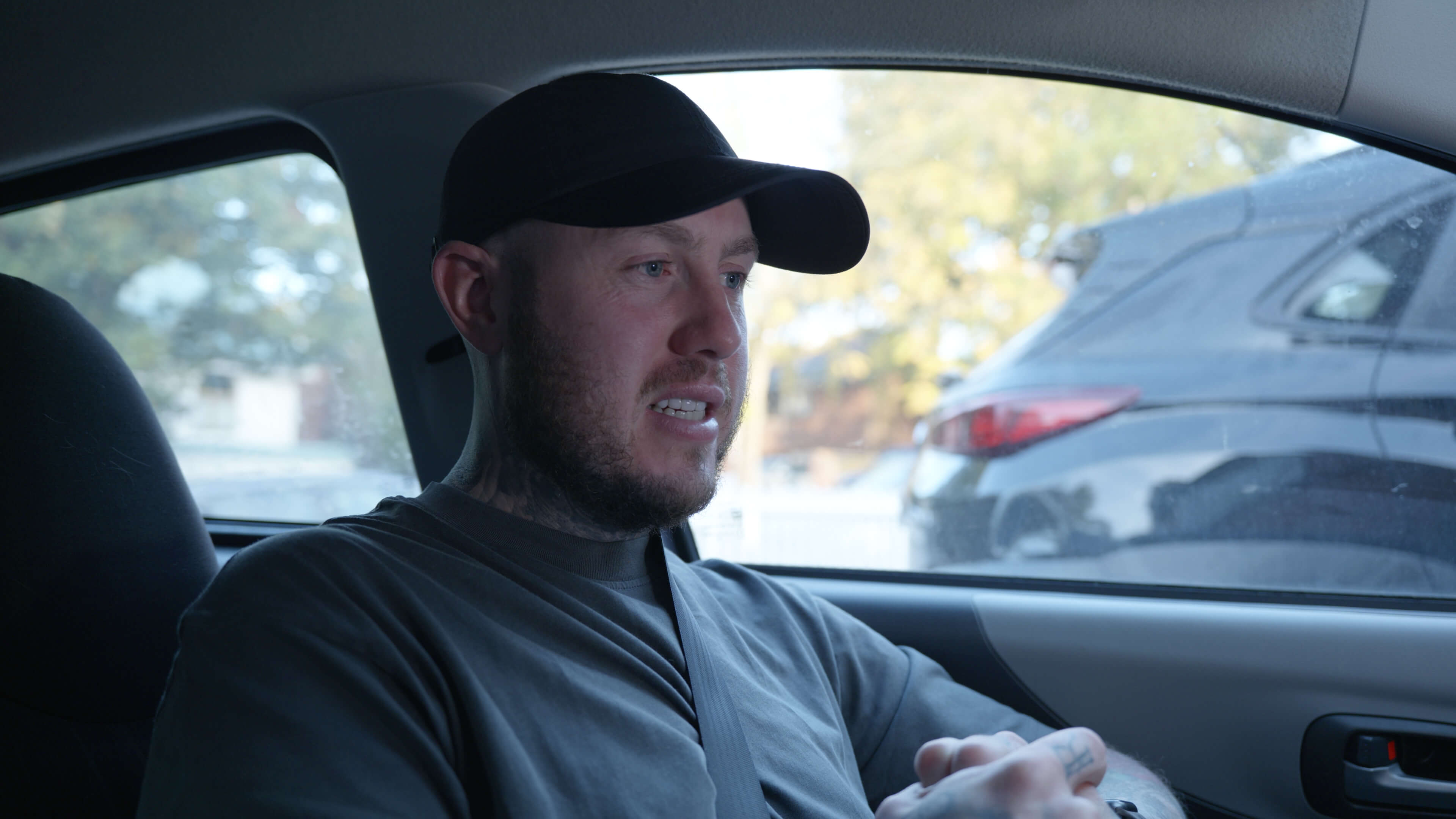 Man giving interview to camera while sitting in car